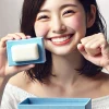 A happy Japanese person holding a blue box containing a white solid soap, expressing joy and satisfaction. The background is clean and bright, symbolizing freshness and quality. The image is horizontal (16:9).